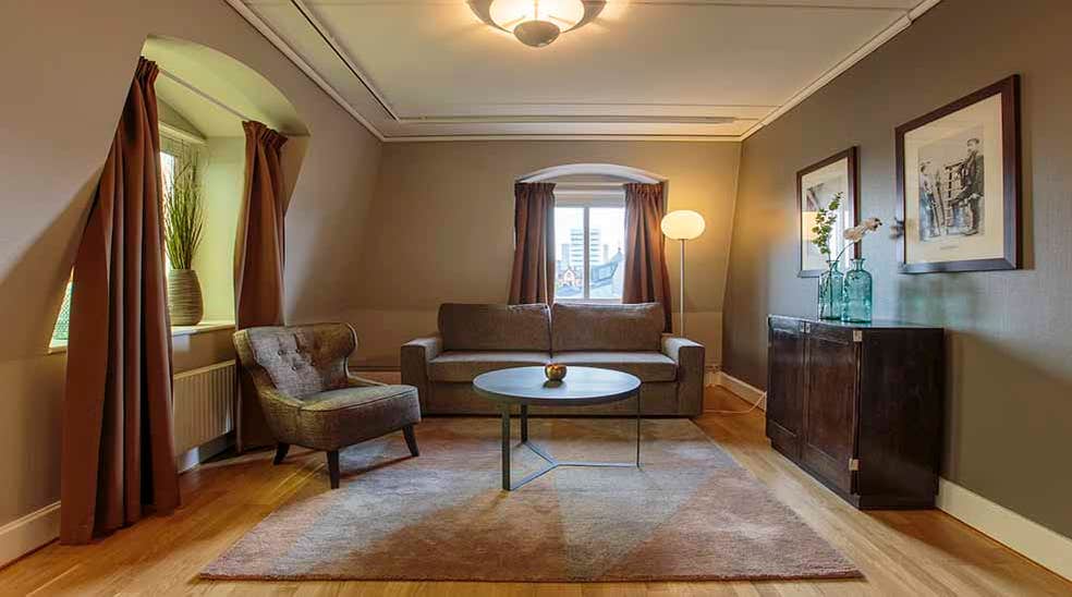 Suite stue med sofa og stoler ved Clarion Collection Hotel Uman Umeå