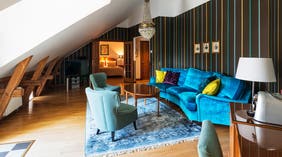 Suite med sitteområde, lenestoler, sofa og lysekrone ved Clarion Hotel Örebro 