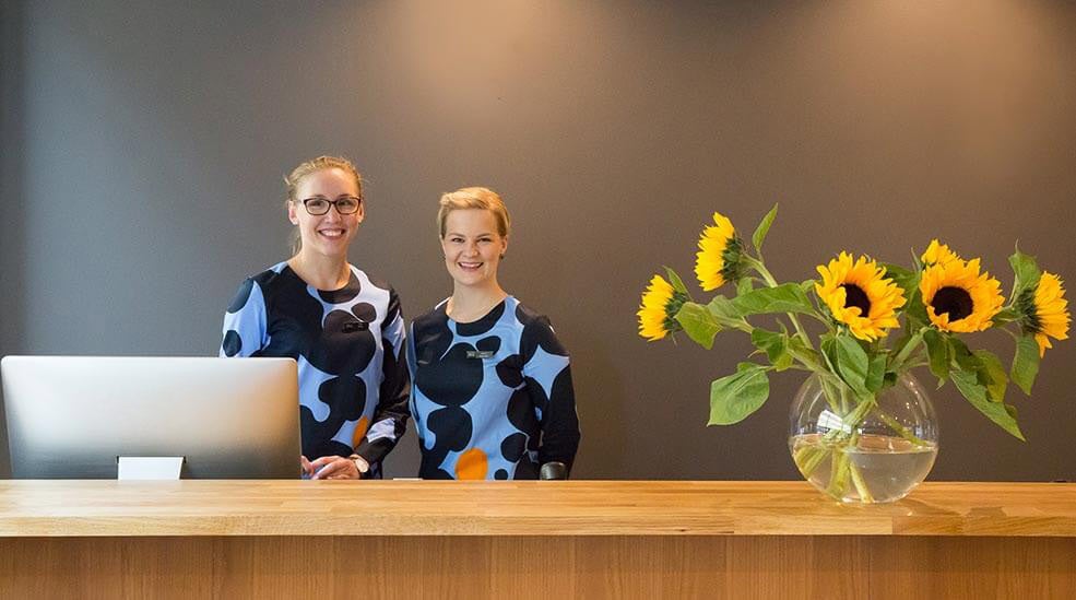 To glade resepsjonister i lobbyen på Hotel F6 i Helsinki, Finland
