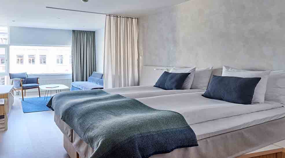 Dobbelseng og sittegruppe i Deluxe hotellrom med vindu på Nordic Light Hotel i Stockholm