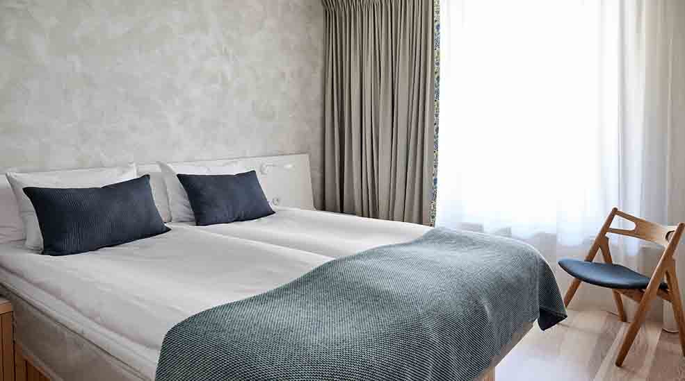 Dobbeltseng og stol i standard single rom med vindu på Nordic Light Hotel i Stockholm