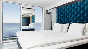Vox Hotel sin store hjørnesuite med dobbeltseng på soverommet og vakker utsikt over innsjøen Vättern